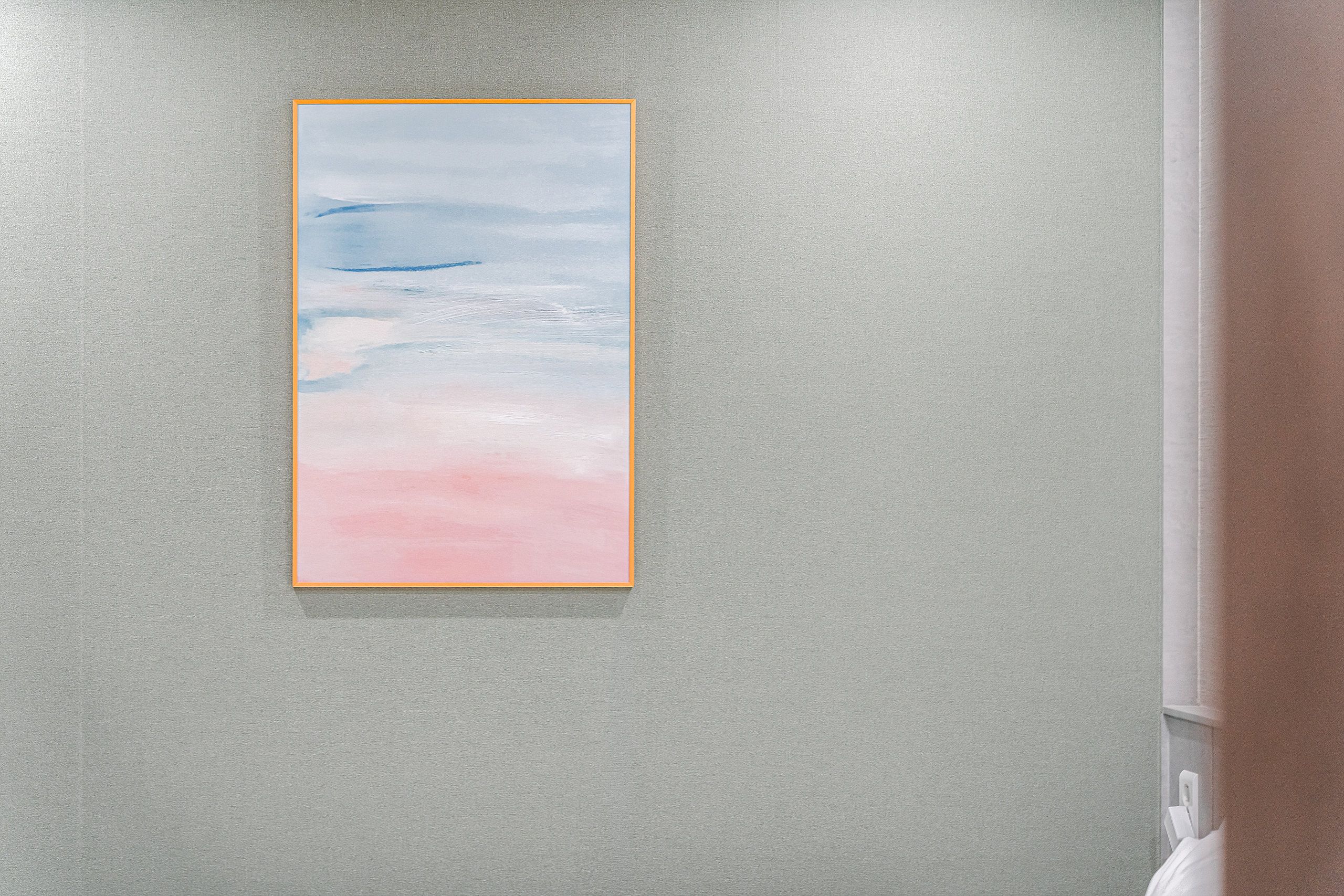 A painting of a landscape with a gradient from blue to pink on a textured wall.