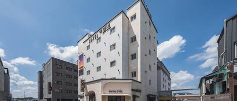 Un hotel con diseño moderno, que presenta una entrada destacada y amplias ventanas.
