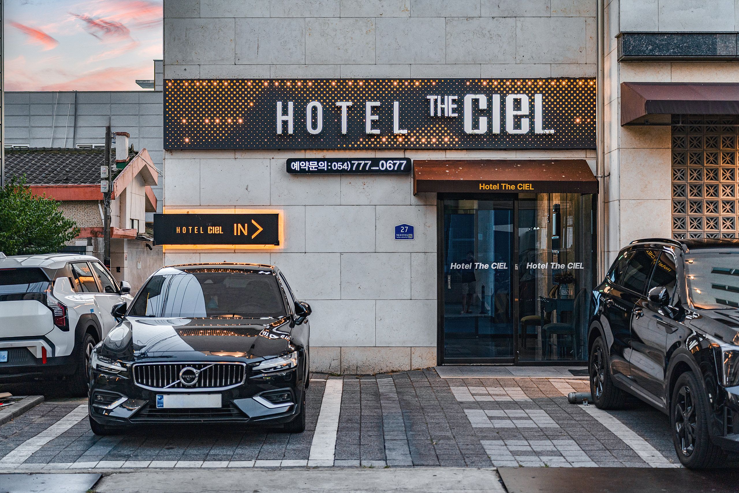 A hotel entrance with a sign reading 'HOTEL THE CIEL' and a visible address.