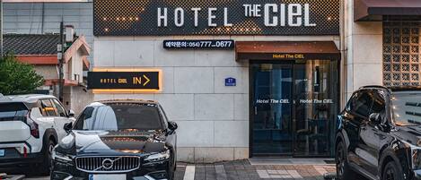 A hotel entrance with a sign reading 'HOTEL THE CIEL' and a visible address.