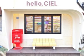 A post office with a bench in front, a red post box, and a window with reflections of cars and buildings. - The Ciel Hotel (Gyeongju)