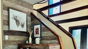 Un intérieur moderne avec un escalier en bois, un banc intégré et une cheminée.
