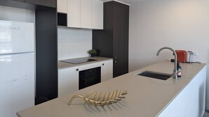 Une cuisine moderne dotée d’un îlot central, d’un four encastré et d’un évier.