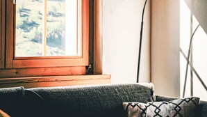 Una habitació amb finestra, una làmpada i un sofà.
