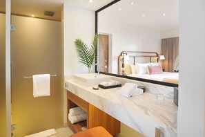 A modern bathroom with a large mirror, a sink, and a shower.