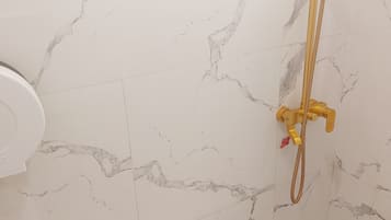 Habitación cuádruple Deluxe | Baño | Regadera, regadera tipo lluvia, bidet, toallas