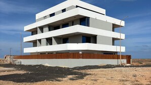 A modern multi-story building with a flat roof and a wooden facade. - Joli Beach House - T1 Beautiful and Authentic Island Living (Sal)