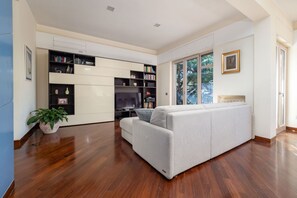 A modern living room with a sofa, a television, and built-in bookshelves.
