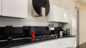 Een moderne keuken met witte kastjes, een zwart aanrecht en een inbouwoven.