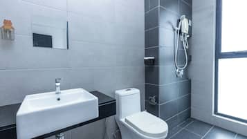 A modern bathroom with a white sink, toilet, and shower.