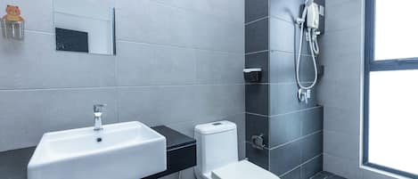 A modern bathroom with a white sink, toilet, and shower.