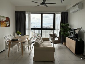 Apartamento conforto, vista para a cidade | Área de estar | Smart TV 43 polegadas com canais a cabo, Netflix, serviços de streaming