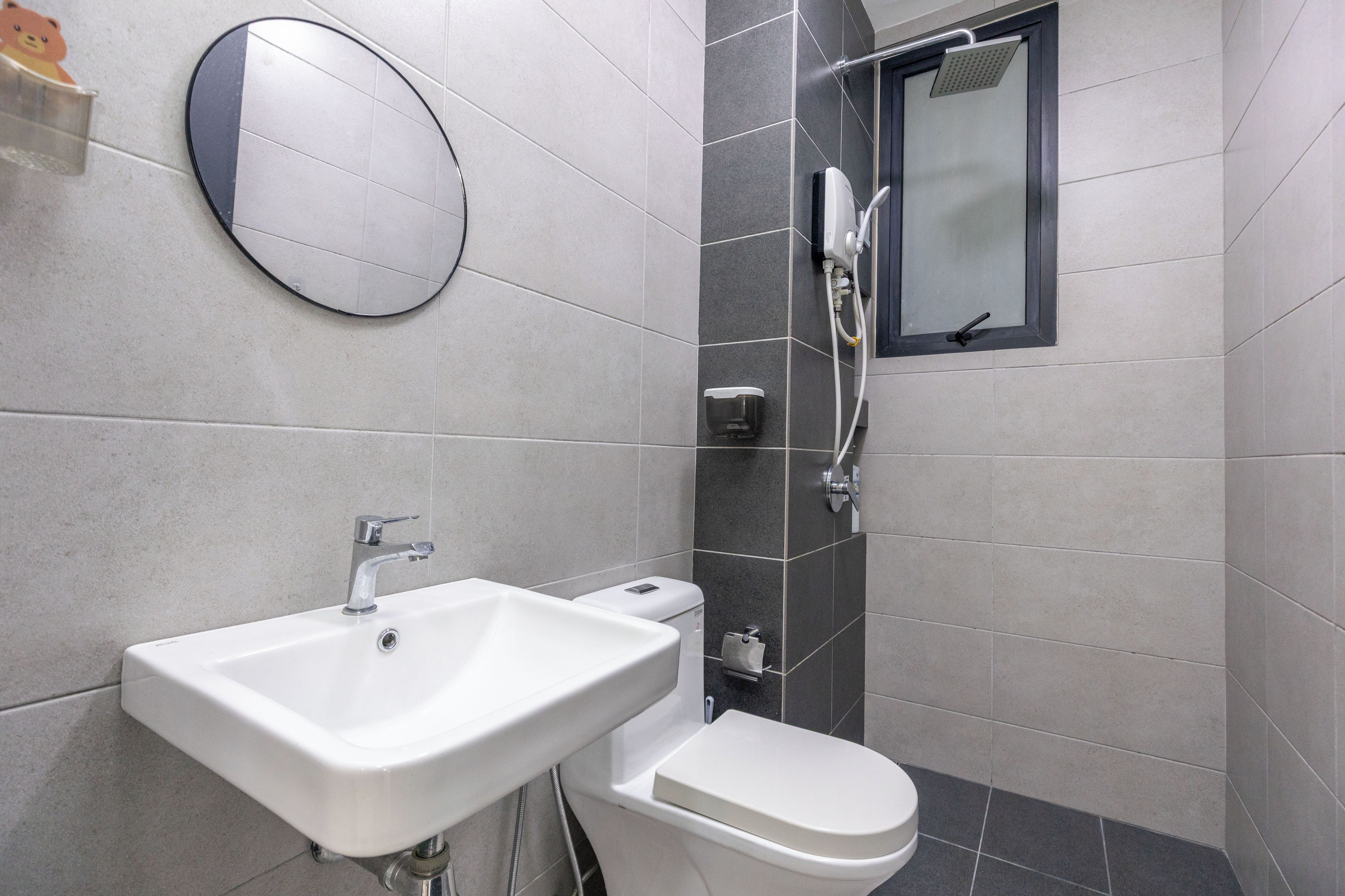Un baño moderno con lavamanos, inodoro y ducha blancos.