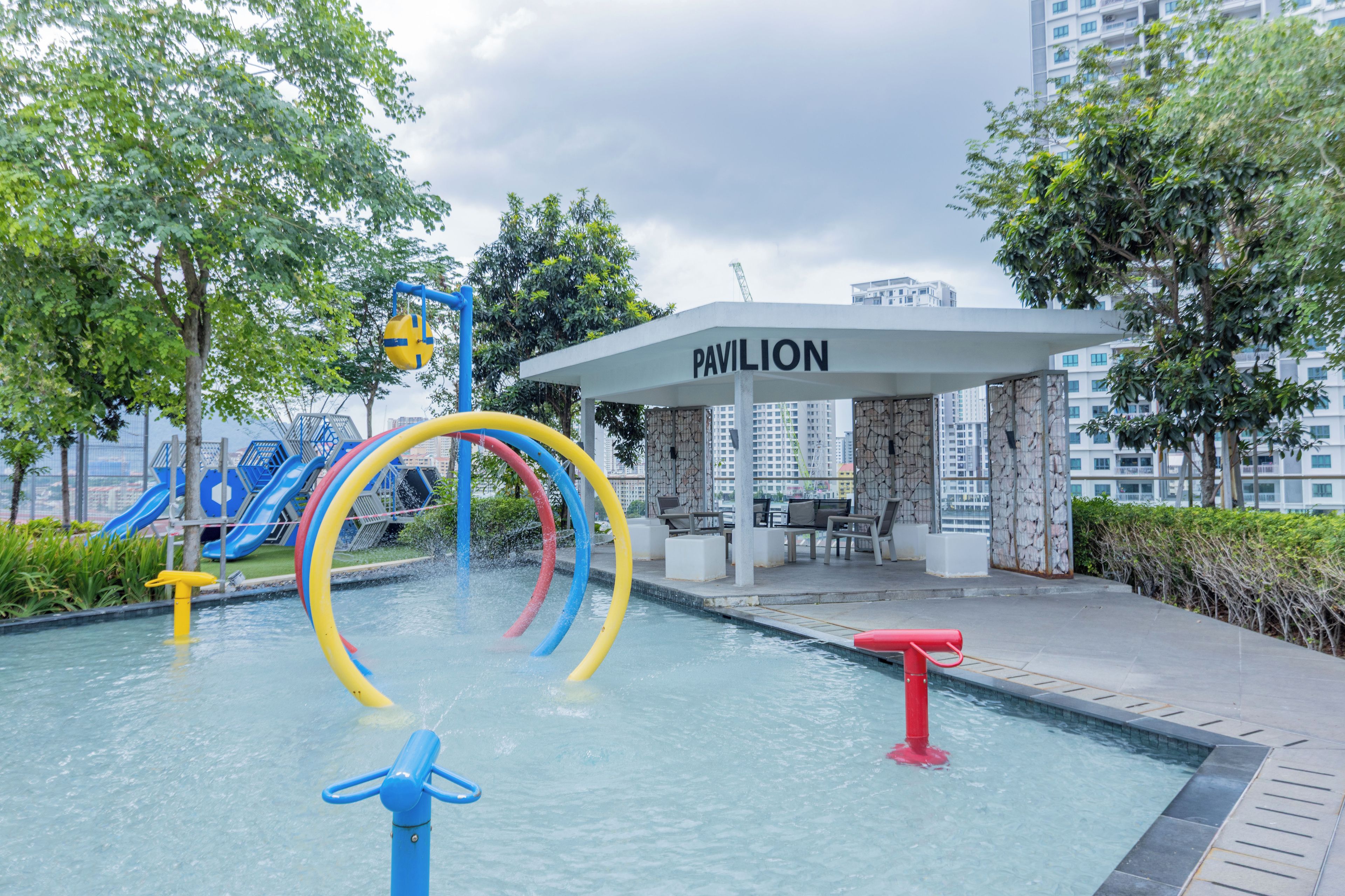 A water play area with slides and a pool, surrounded by greenery and a pavilion labeled 'PAVILION'.