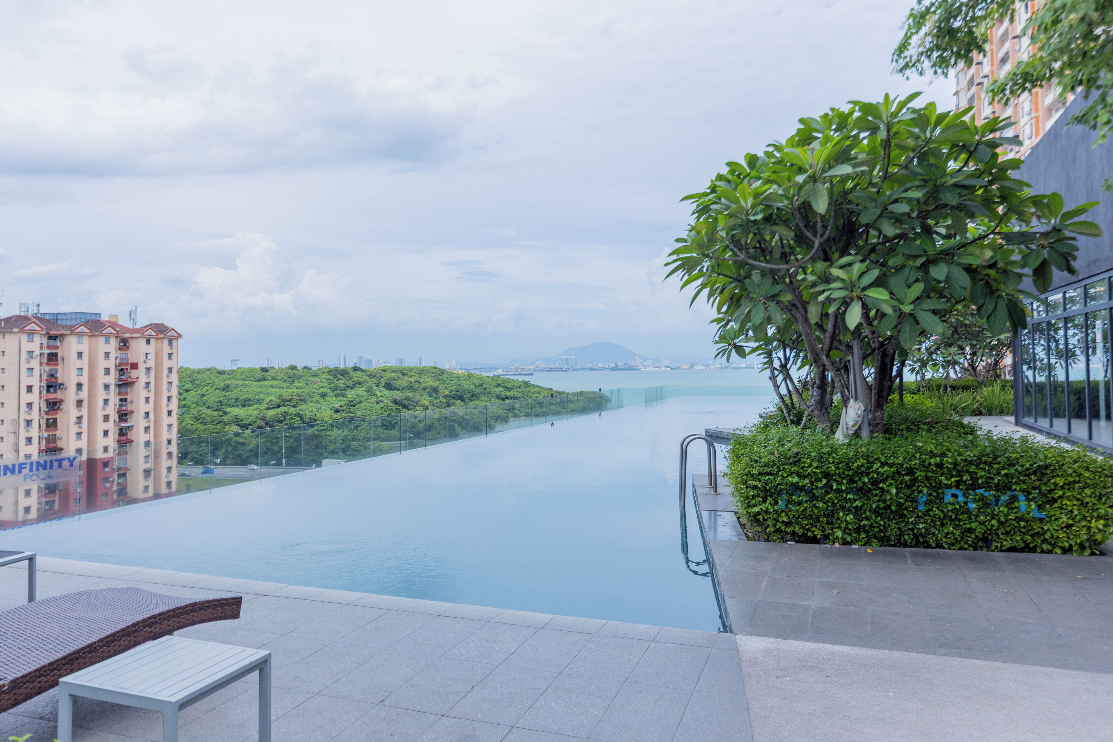 A residential building with a view of a river and greenery.