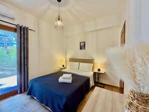A hotel room with a bed, bedside lamps, a window with curtains, a ceiling light, and a decorative vase.