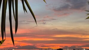 A sunset view with silhouettes of distant mountains and a body of water. - 康宿·海映居 | KanStay Oceanview Residence 4005 | 2BR 2BA · Manila Bay View (Manila)