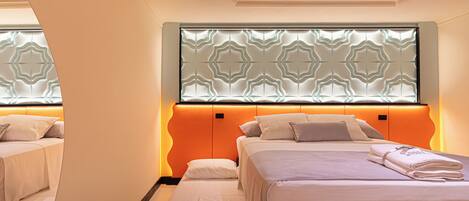 Een hotelkamer met twee bedden, een decoratief plafond en een bekleder met patroon.