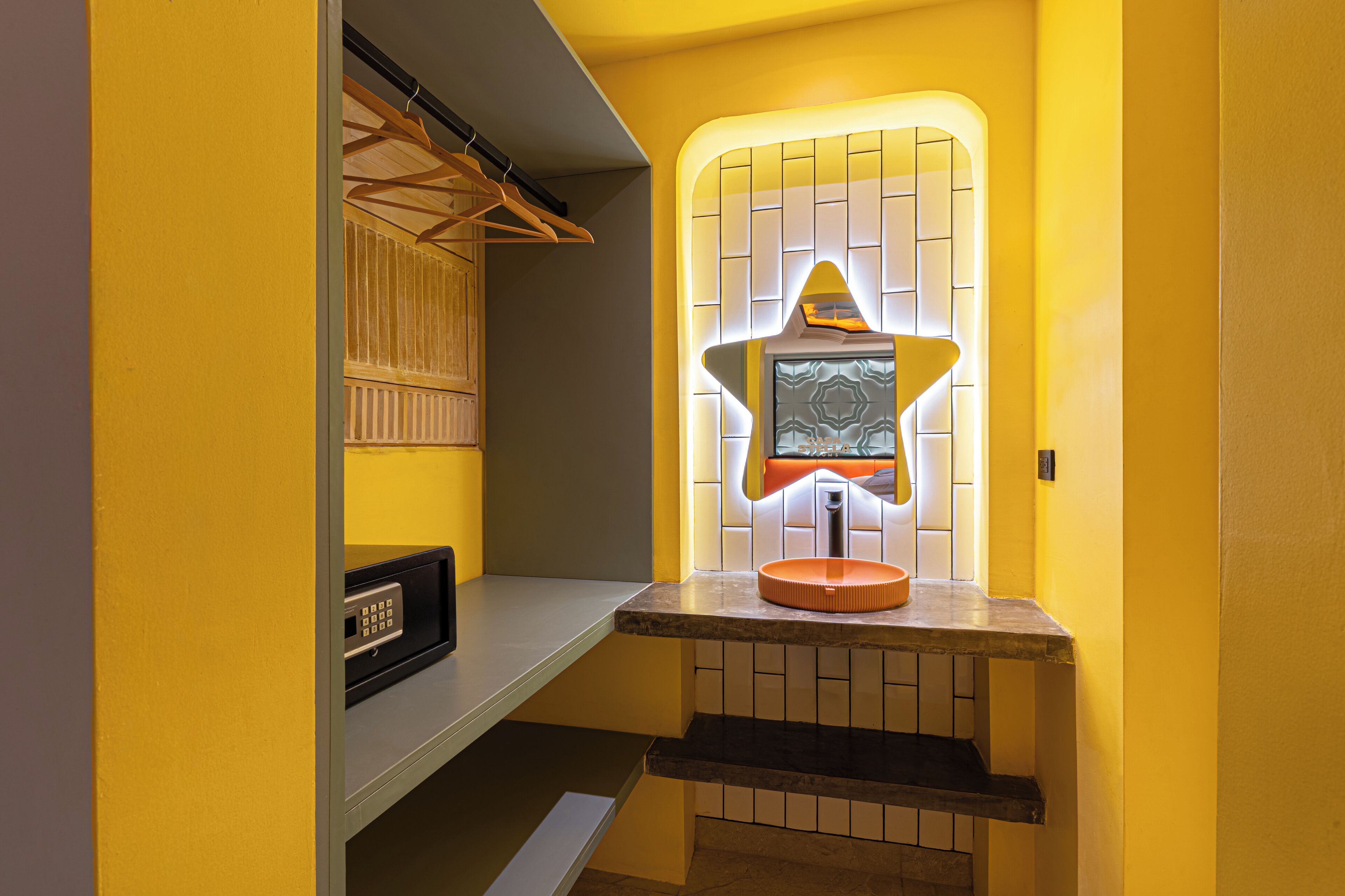 A bathroom with a star-shaped mirror, a towel rack, and a sink.