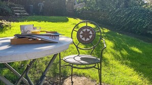 A round table with a chair, a glass of orange juice, and a book. - 3 bedroom accommodation in Osmotherley, near Brompton (Osmotherley, near Brompton)