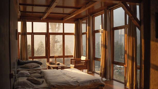 A bedroom with a large bed, a desk, and multiple windows. - The Hidden Treasure (Sosan)