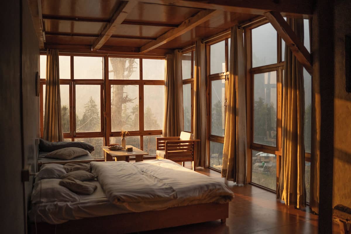 Un dormitorio con una cama grande, un escritorio y varias ventanas.