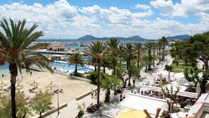 A coastal resort with a beach, palm trees, and a marina.