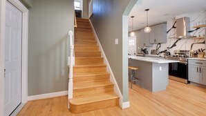 A modern kitchen with wooden flooring, a central island, and stainless steel appliances. - 8 Mi to DC: Cheverly Apt w/ Easy Metro Access (Cheverly)