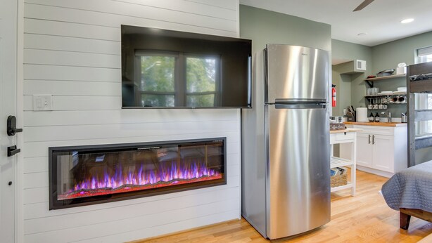 A modern kitchen with a built-in fireplace, stainless steel appliances, and a wooden floor. - Commuter's Dream! Cheverly Studio 1/2 Mi to Metro (Cheverly)