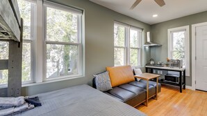 A bedroom with a bed, a desk, a kitchenette, and large windows. - Commuter's Dream! Cheverly Studio 1/2 Mi to Metro (Cheverly)