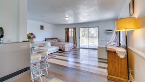 Una habitación amplia con cama, comedor y cocina.
