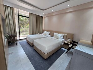 A modern hotel room with two beds, a desk, and a chair. - Chuti Aronnobash Resort (Gazipur)