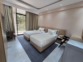 Una habitación de hotel moderna con dos camas, un escritorio y una silla.