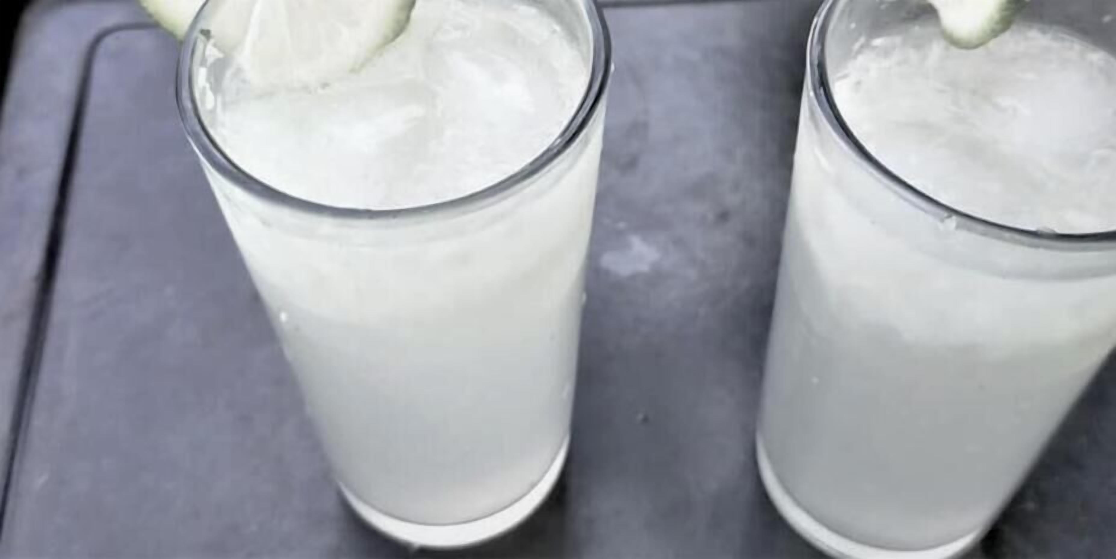 Twee glaasjes heldere drank met ijs en een schijfje limoen, geplaatst op een dienblad.