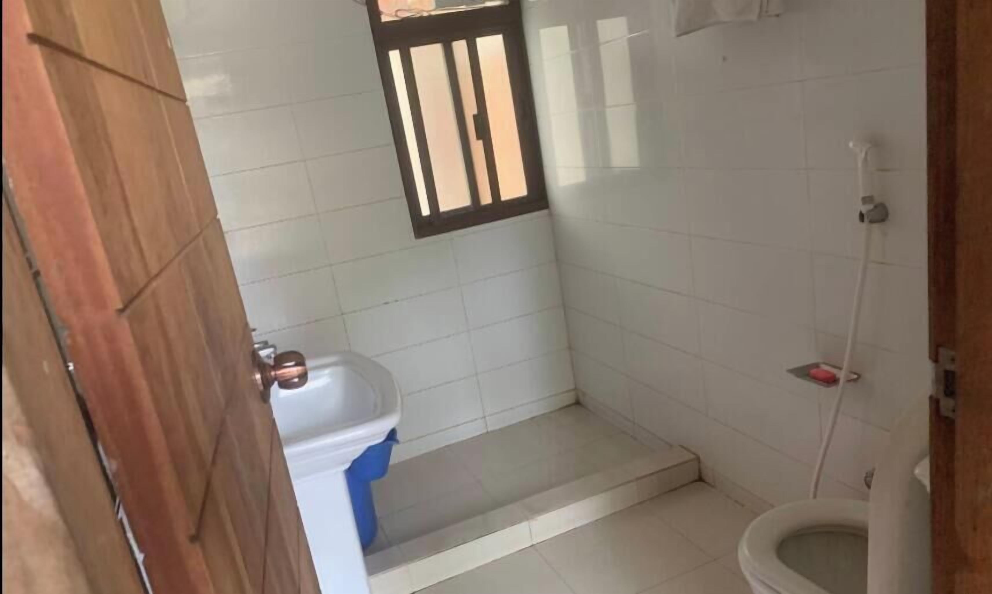 A bathroom with a toilet, sink, and shower.