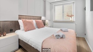 Una camera da letto moderna con un letto, comodini, una finestra con vista e un vaso decorativo.