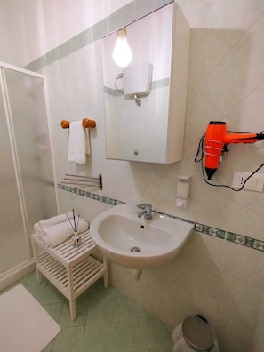 Een douche, een haardroger, een bidet, handdoeken