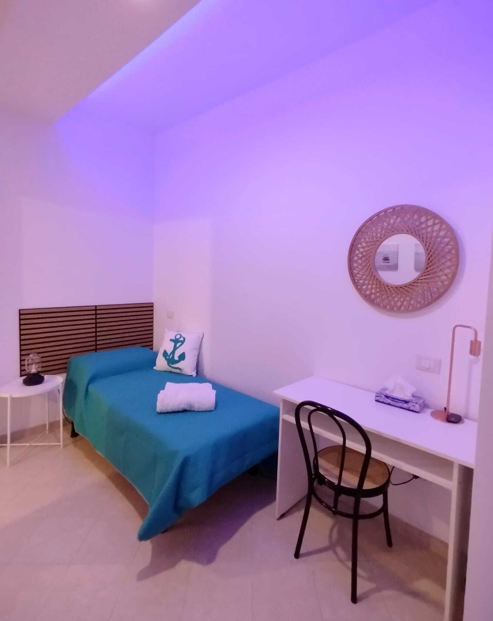 Ein kleines, modernes Schlafzimmer mit einem Bett, einem Schreibtisch und einem Stuhl.