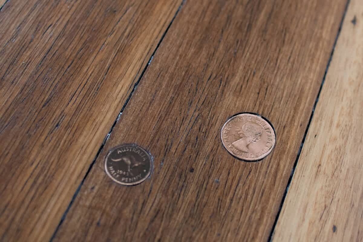 Two coins on a wooden surface.