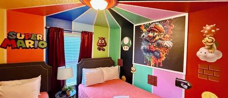 A Super Mario themed room with a bed, two nightstands, a ceiling fan, and wall decorations including a Mario poster and Toad character.