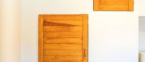 A bathroom with white tiled walls, wooden beams, and two wooden panels on the wall.