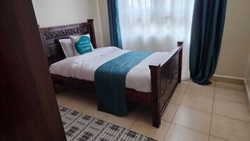 Tabla de planchar con plancha, internet y ropa de cama