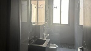 Une salle de bain moderne avec une douche à parois de verre, un lavabo intégré et des toilettes.