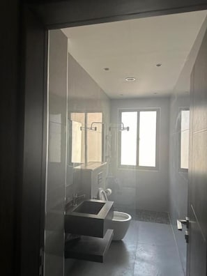 Ducha, artículos de higiene personal gratuitos, zapatillas y toallas