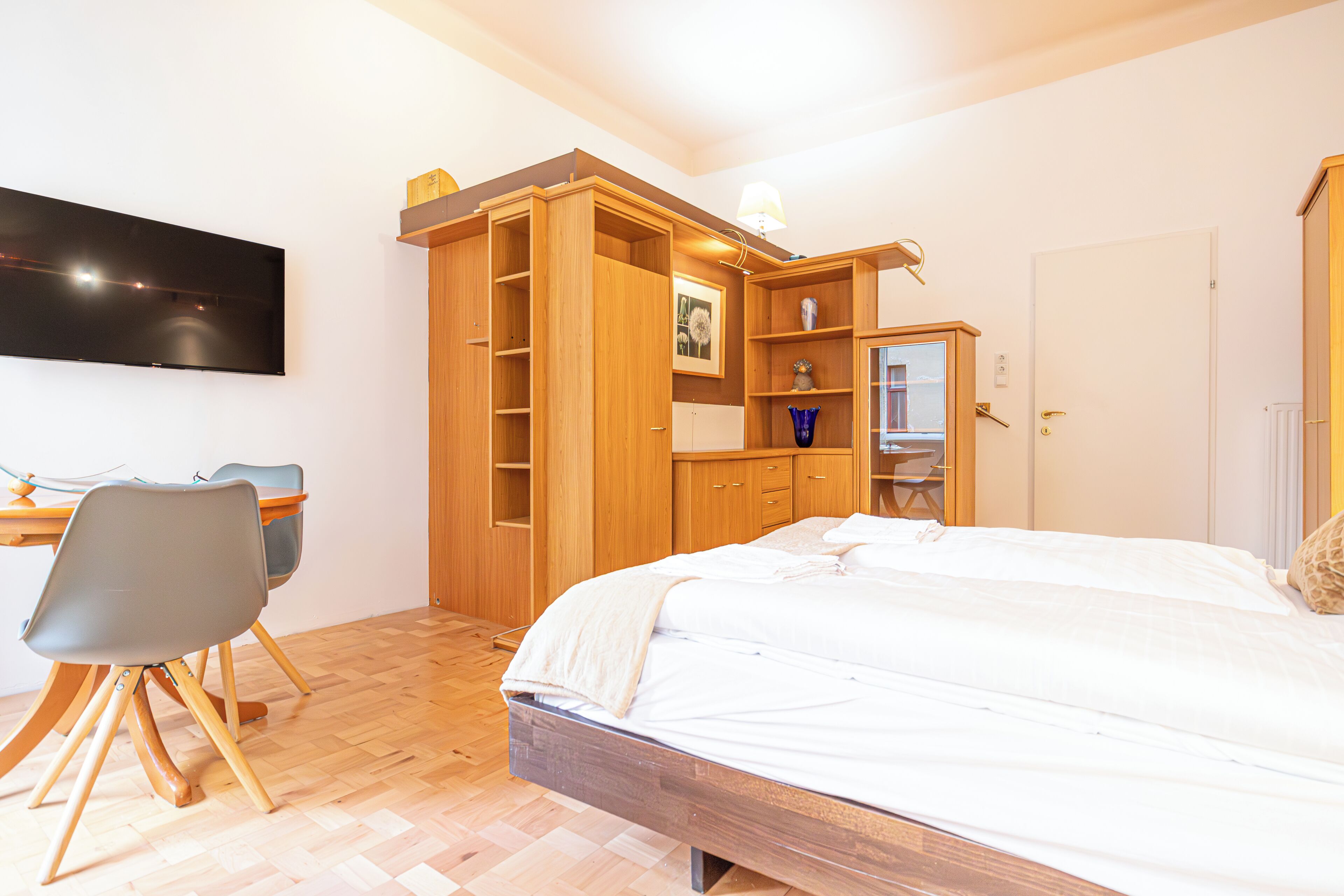 A bedroom with a bed, a desk, and a chair.