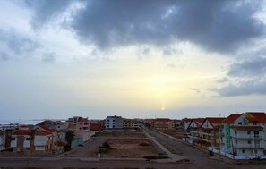 Una zona residencial costera con edificios, una carretera y una playa al fondo.
