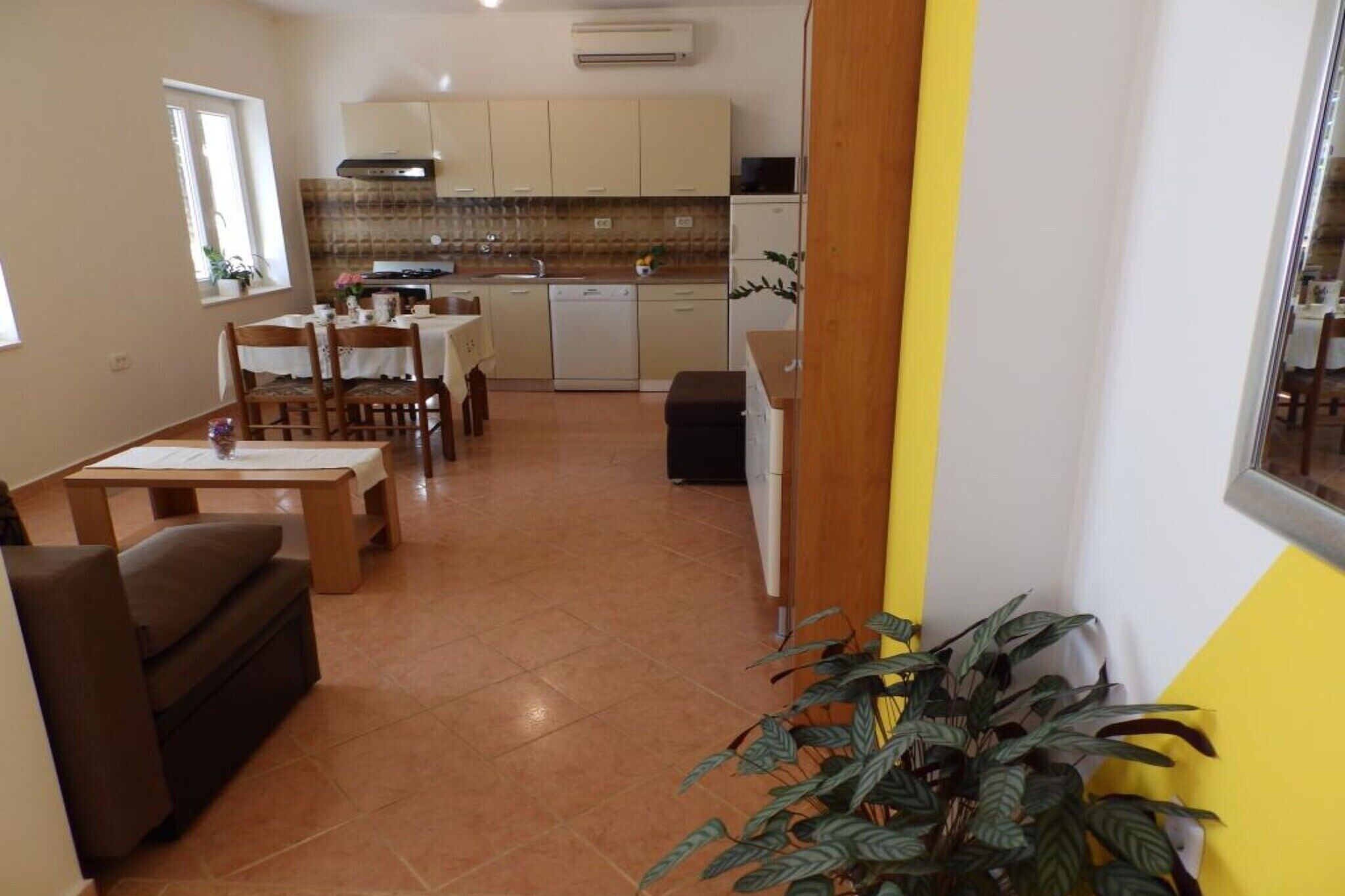 Un espace de vie compact comprenant un coin repas, une kitchenette et un canapé.