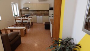 Un espacio habitable compacto con comedor, kitchenette y sofá.