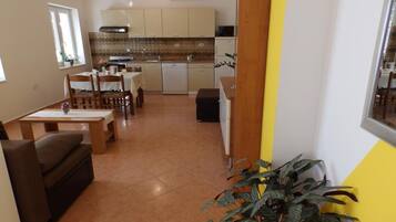 Un espace de vie compact comprenant un coin repas, une kitchenette et un canapé.