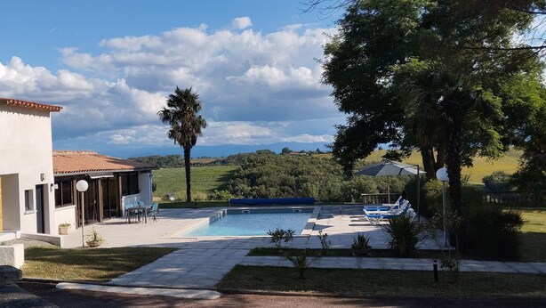 A modern villa with a swimming pool, outdoor seating, and a view of the countryside. - Gite Casa Tutel (Esperce)